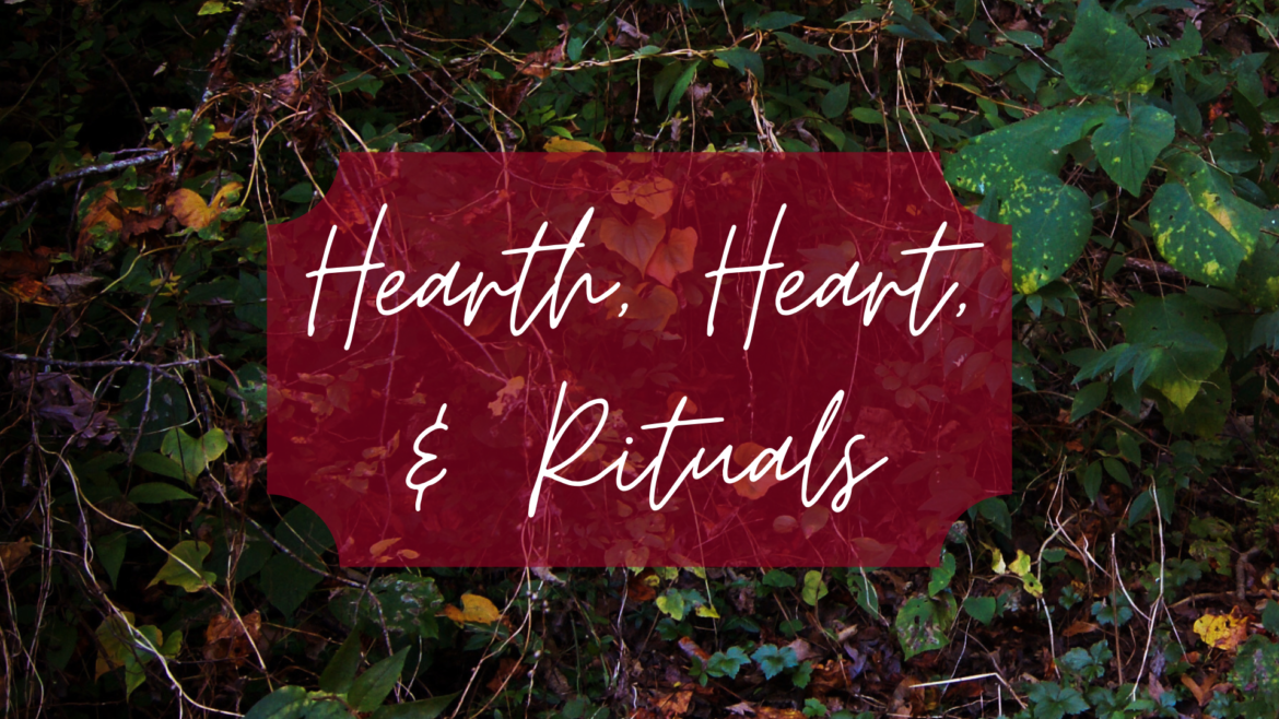 Text "Hearth, Heart, & Rituals" in white cursive is overlaid on a red banner, set against a background of lush, green foliage and vines.